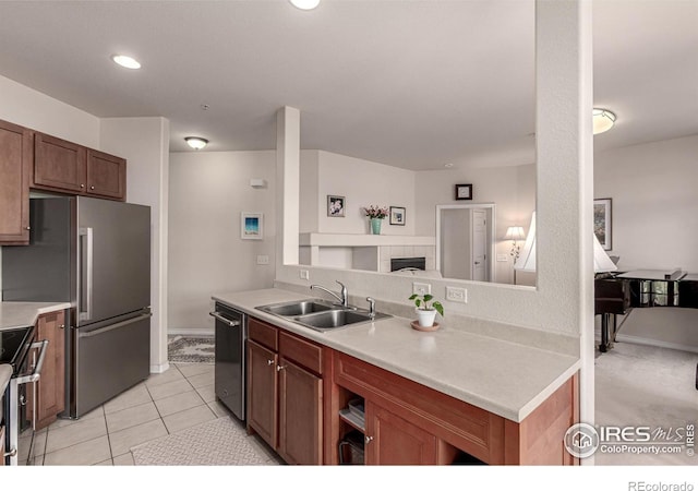 kitchen featuring a sink, baseboards, appliances with stainless steel finishes, light countertops, and light tile patterned floors