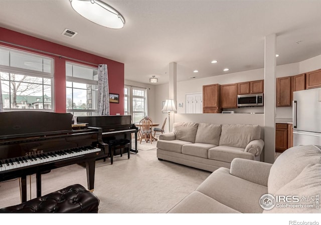 living room featuring recessed lighting, visible vents, and light carpet