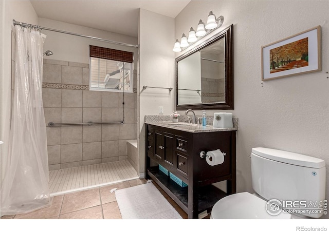 full bathroom featuring tile patterned floors, a tile shower, vanity, and toilet