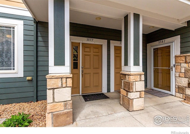 property entrance featuring stone siding and covered porch
