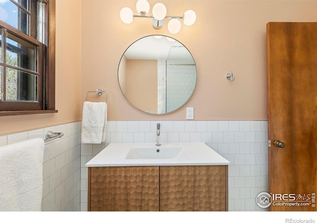 bathroom featuring tile walls, wainscoting, and vanity