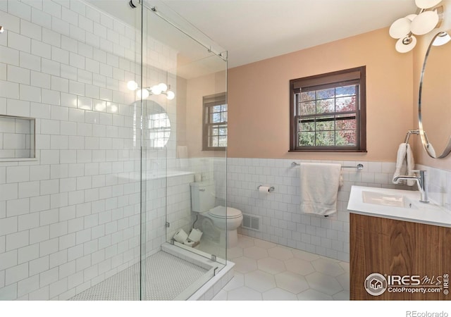 full bath featuring tile patterned floors, a stall shower, vanity, tile walls, and visible vents