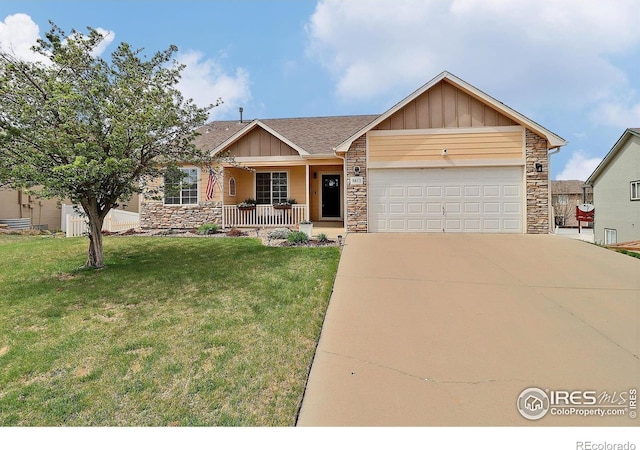 view of front facade featuring stone siding, a porch, a front yard, and a garage