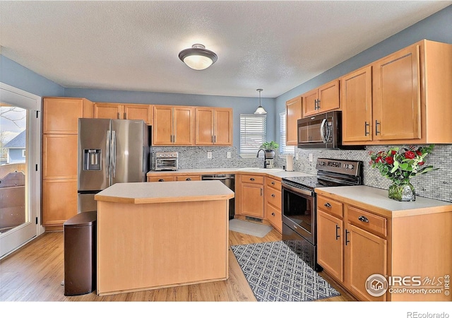 kitchen with tasteful backsplash, stainless steel appliances, light countertops, and light wood-type flooring
