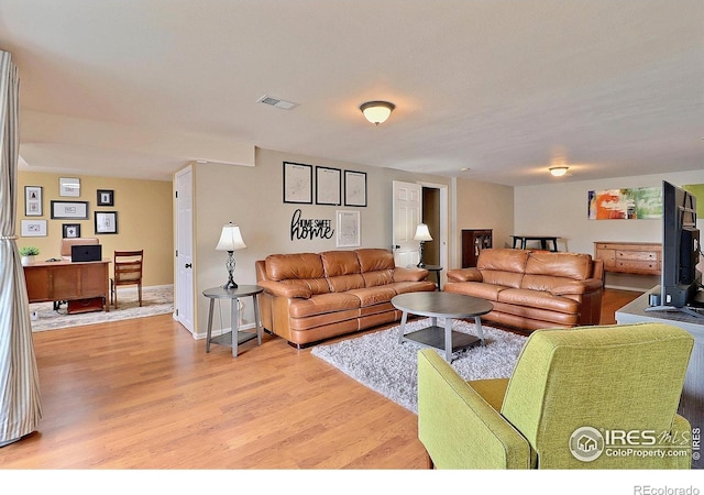 living area with light wood-style floors and visible vents