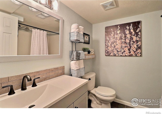 bathroom with curtained shower, visible vents, toilet, vanity, and baseboards