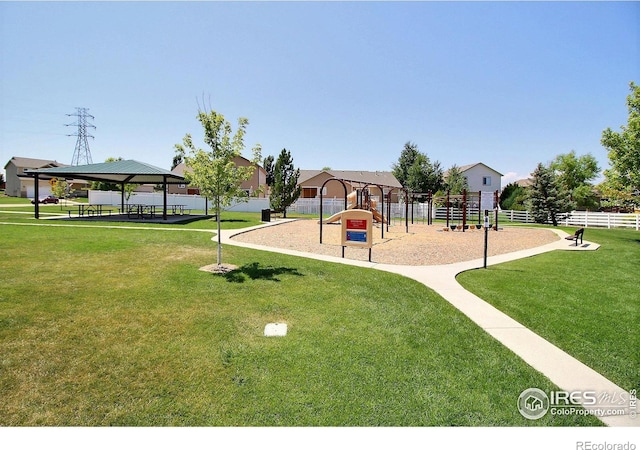 communal playground featuring a lawn, a gazebo, and fence