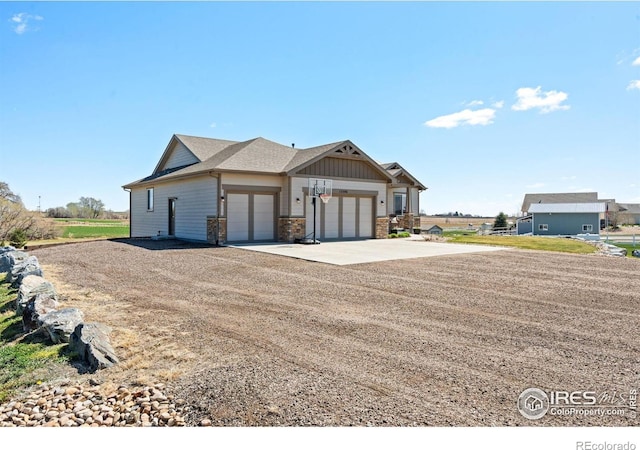 view of front of property featuring a garage, stone siding, and concrete driveway