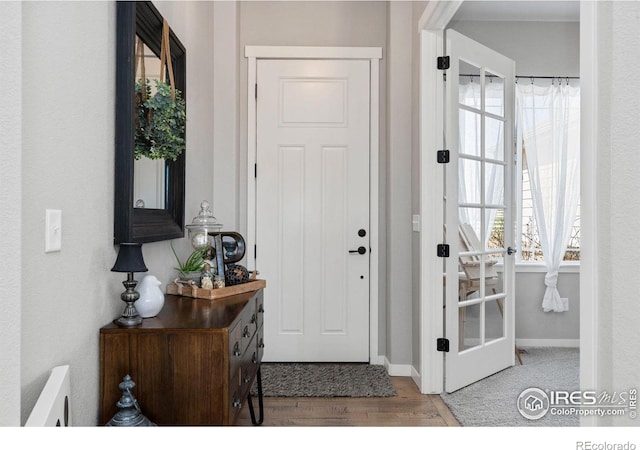 foyer with baseboards and wood finished floors