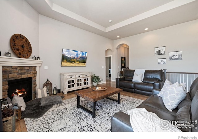 living area featuring a fireplace, wood finished floors, arched walkways, and recessed lighting