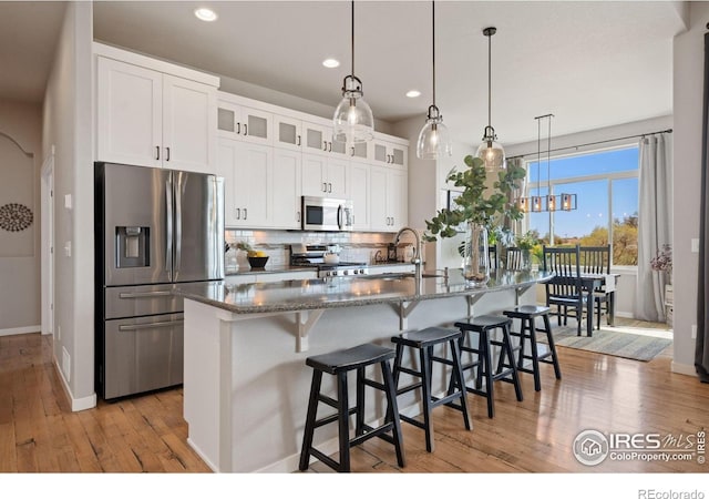 kitchen with a sink, tasteful backsplash, baseboards, recessed lighting, and appliances with stainless steel finishes