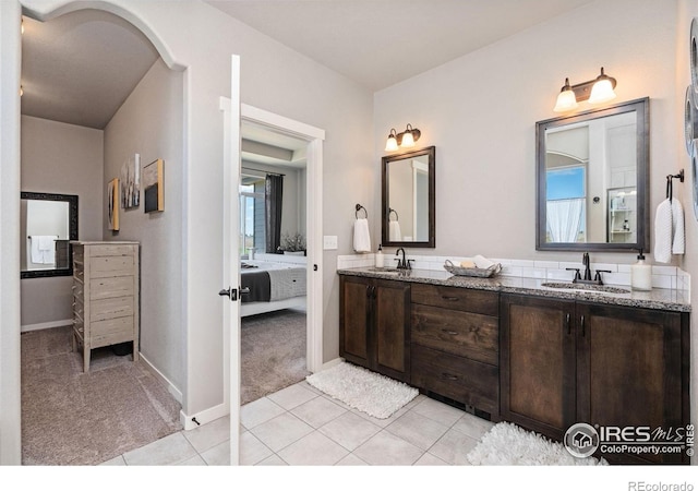 ensuite bathroom featuring ensuite bath, tile patterned floors, a sink, and double vanity