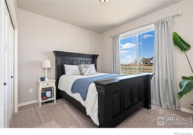 bedroom featuring baseboards and light carpet