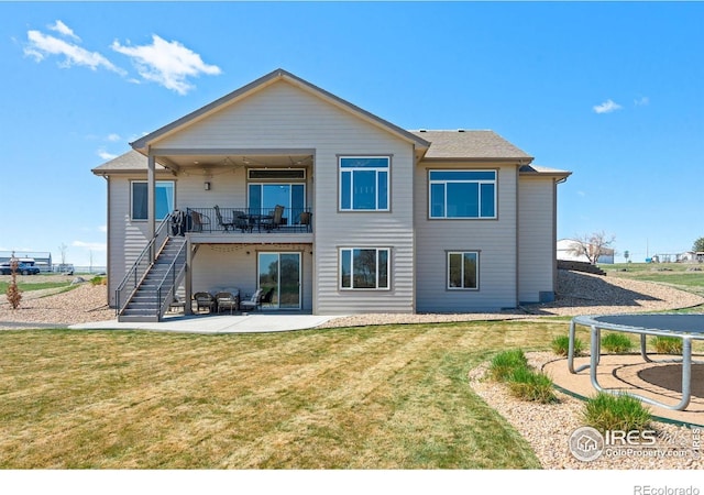 rear view of property with stairway, a balcony, a yard, and a patio