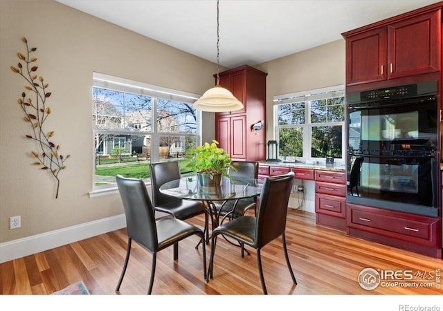 dining space featuring light wood-style floors, plenty of natural light, and baseboards