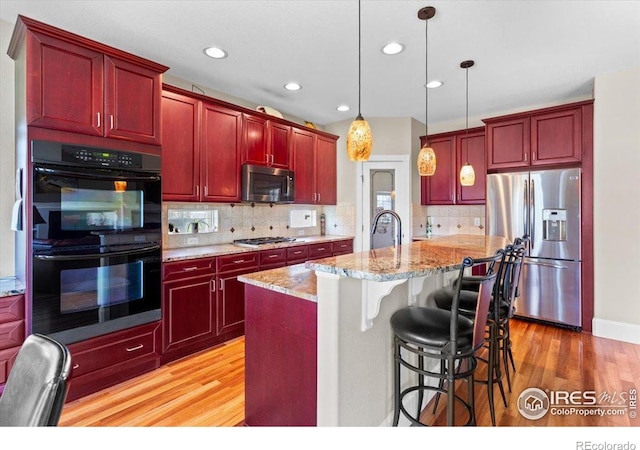 kitchen featuring dark brown cabinets, light wood-style flooring, and appliances with stainless steel finishes