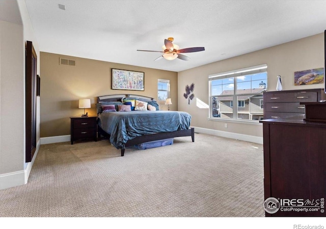 bedroom featuring baseboards, visible vents, and light colored carpet