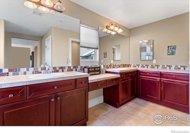 bathroom with visible vents, tile patterned floors, vanity, and decorative backsplash