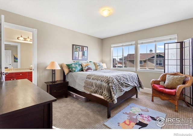 bedroom featuring carpet flooring and connected bathroom