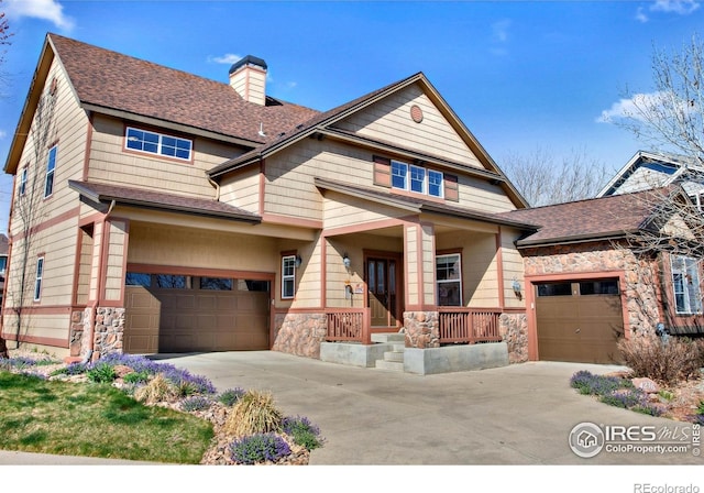 craftsman inspired home featuring a chimney, driveway, stone siding, a shingled roof, and a porch