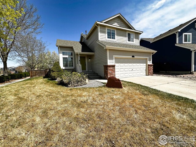6502 Carmichael St, Fort Collins, CO 80528 - view of front of property with fence, an attached garage, driveway, brick siding, and a front yard