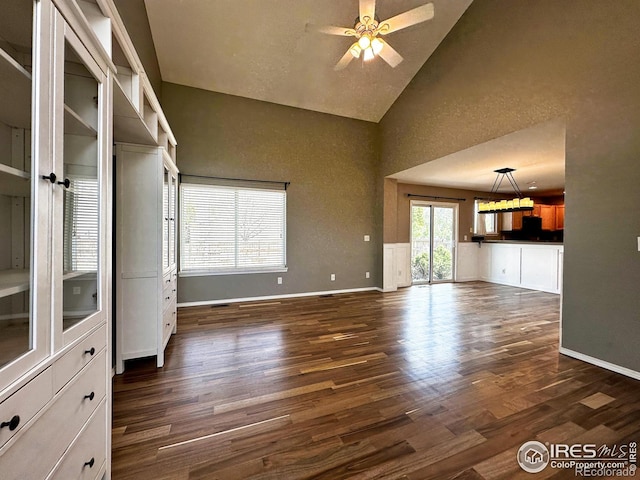 6502 Carmichael St, Fort Collins, CO 80528 - unfurnished living room with a ceiling fan, baseboards, high vaulted ceiling, and dark wood-type flooring