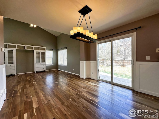 6502 Carmichael St, Fort Collins, CO 80528 - unfurnished dining area with high vaulted ceiling, dark wood-style floors, a wainscoted wall, a notable chandelier, and visible vents