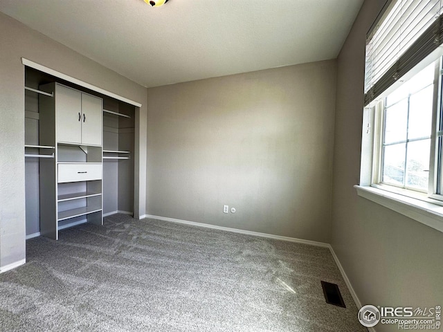 6502 Carmichael St, Fort Collins, CO 80528 - unfurnished bedroom featuring a closet, dark colored carpet, visible vents, and baseboards