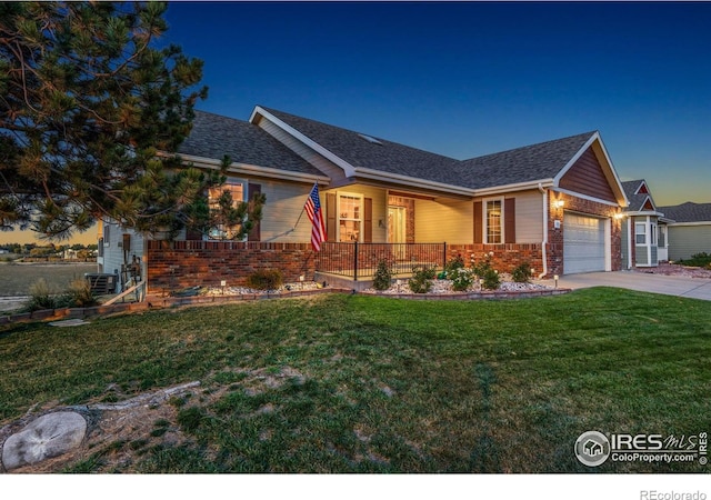 7421 18th St, Greeley, CO 80634 - single story home with brick siding, a garage, a front yard, and covered porch