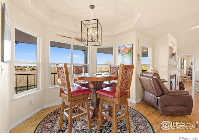 7421 18th St, Greeley, CO 80634 - dining area featuring a raised ceiling, an inviting chandelier, light wood finished floors, and baseboards