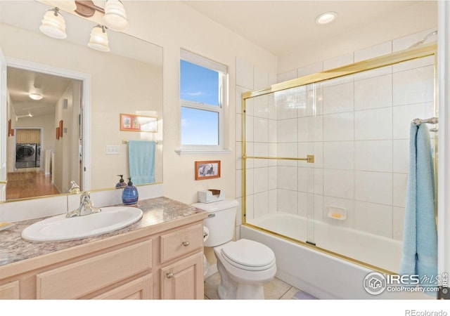 7421 18th St, Greeley, CO 80634 - full bath with shower / bath combination with glass door, toilet, vanity, and washer and clothes dryer