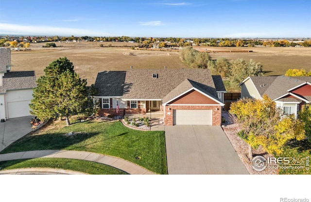 7421 18th St, Greeley, CO 80634 - view of front of home with a front lawn, driveway, brick siding, and a garage