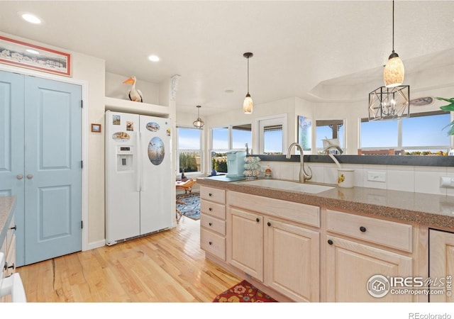 7421 18th St, Greeley, CO 80634 - kitchen with a sink, white refrigerator with ice dispenser, light brown cabinetry, light wood-style floors, and recessed lighting