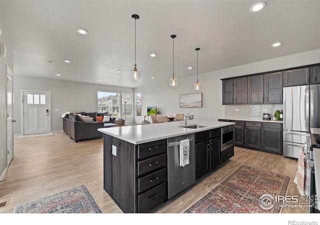 2838 Sykes Dr, Fort Collins, CO 80524 - kitchen featuring stainless steel appliances, a sink, tasteful backsplash, light wood-type flooring, and light countertops
