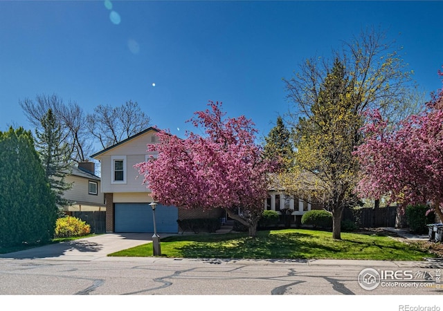 2417 15th Ave, Longmont, CO 80503 - view of property hidden behind natural elements with a garage, a front lawn, concrete driveway, and fence