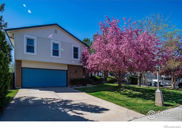 2417 15th Ave, Longmont, CO 80503 - view of front of property featuring concrete driveway, an attached garage, brick siding, and a front yard