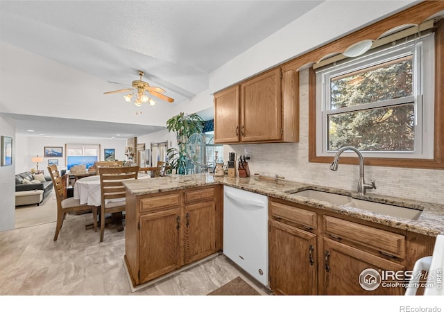 2417 15th Ave, Longmont, CO 80503 - kitchen with a ceiling fan, white dishwasher, a sink, brown cabinetry, and a peninsula