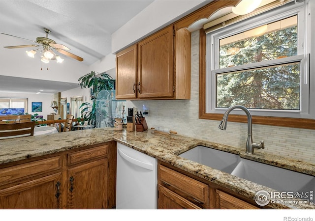 2417 15th Ave, Longmont, CO 80503 - kitchen featuring brown cabinets, backsplash, dishwasher, a sink, and ceiling fan