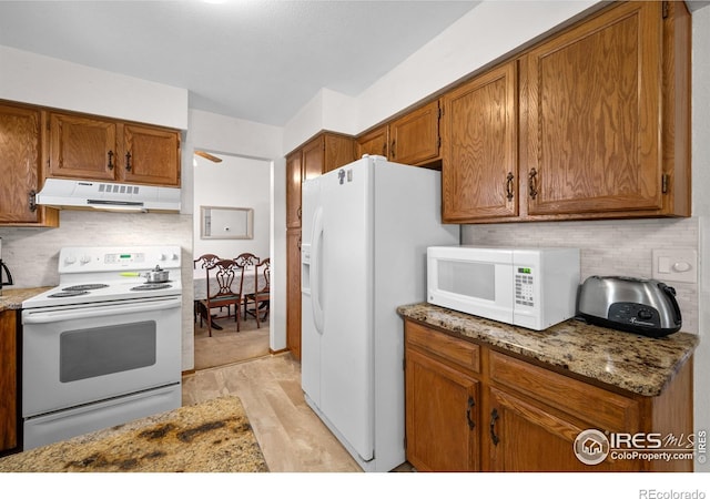 2417 15th Ave, Longmont, CO 80503 - kitchen featuring backsplash, under cabinet range hood, white appliances, and brown cabinetry