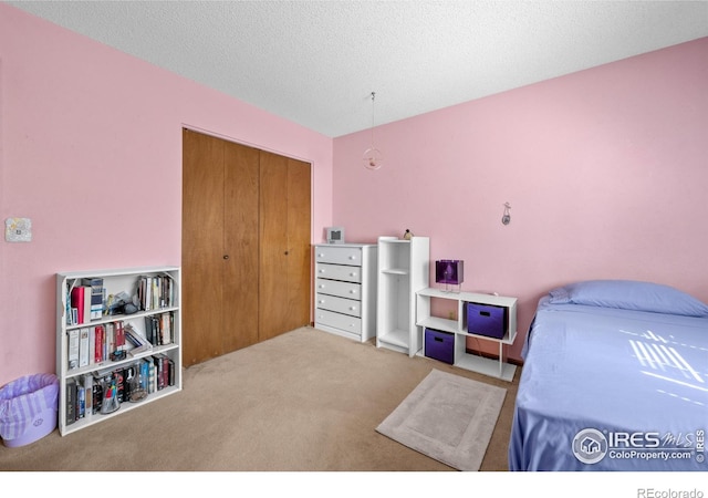 2417 15th Ave, Longmont, CO 80503 - bedroom with carpet floors, a textured ceiling, and a closet