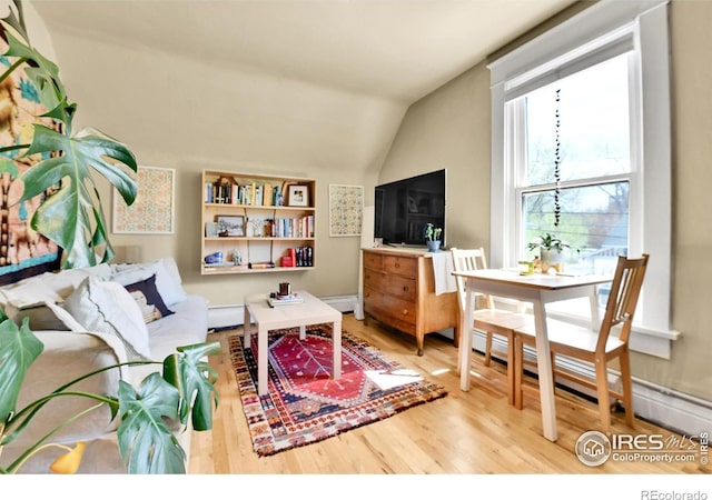 living room with baseboard heating, a baseboard radiator, vaulted ceiling, and wood finished floors