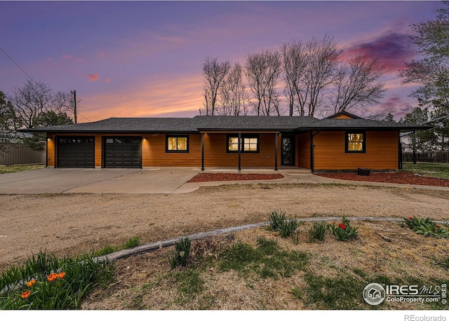 24683 US Highway 34, Fort Morgan, CO 80701 - view of front of house featuring a garage, fence, concrete driveway, and a porch