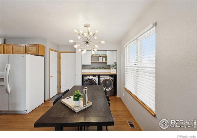 1114 Berwick Ct, Fort Collins, CO 80524 - dining space with a chandelier, washing machine and dryer, and light wood-style floors