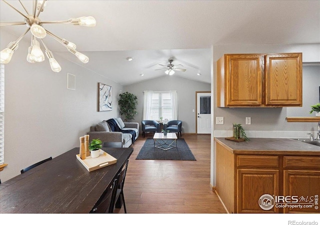 1114 Berwick Ct, Fort Collins, CO 80524 - kitchen with lofted ceiling, wood-type flooring, ceiling fan, dark countertops, and brown cabinets