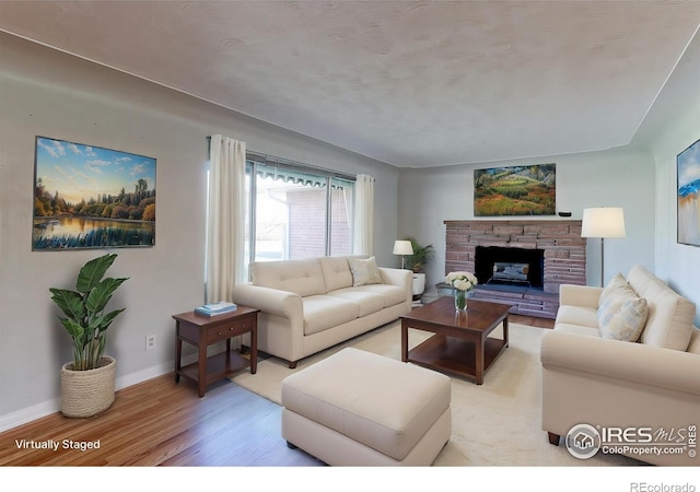 4580 Balsam St, Wheat Ridge, CO 80033 - living area with light wood finished floors, baseboards, and a fireplace