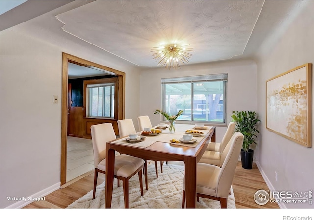 4580 Balsam St, Wheat Ridge, CO 80033 - dining area with healthy amount of natural light, light wood-style flooring, baseboards, and a chandelier
