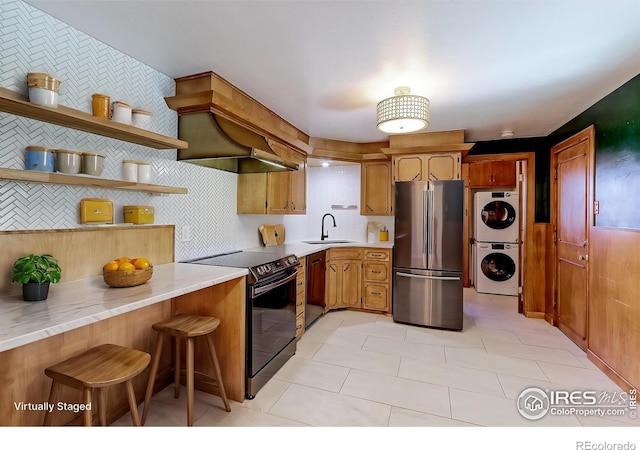 4580 Balsam St, Wheat Ridge, CO 80033 - kitchen featuring black appliances, a sink, estacked washer and dryer, and light countertops