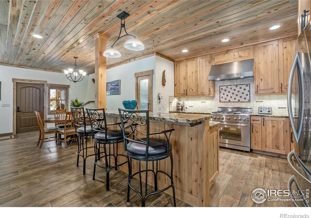 223 Kings Canyon Rd, Bellvue, CO 80512 - kitchen featuring appliances with stainless steel finishes, under cabinet range hood, stone countertops, a kitchen bar, and wooden ceiling