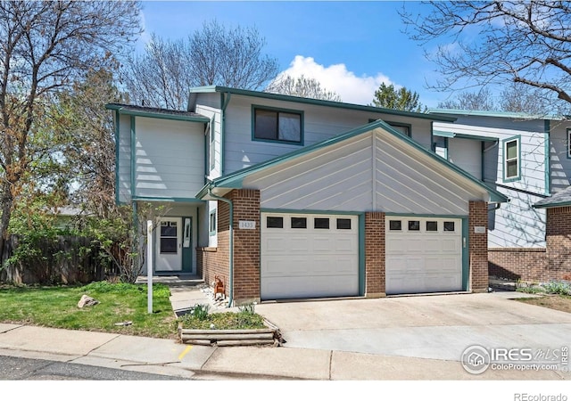 traditional home featuring brick siding, an attached garage, and driveway