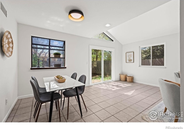 dining area featuring vaulted ceiling, baseboards, and tile patterned flooring